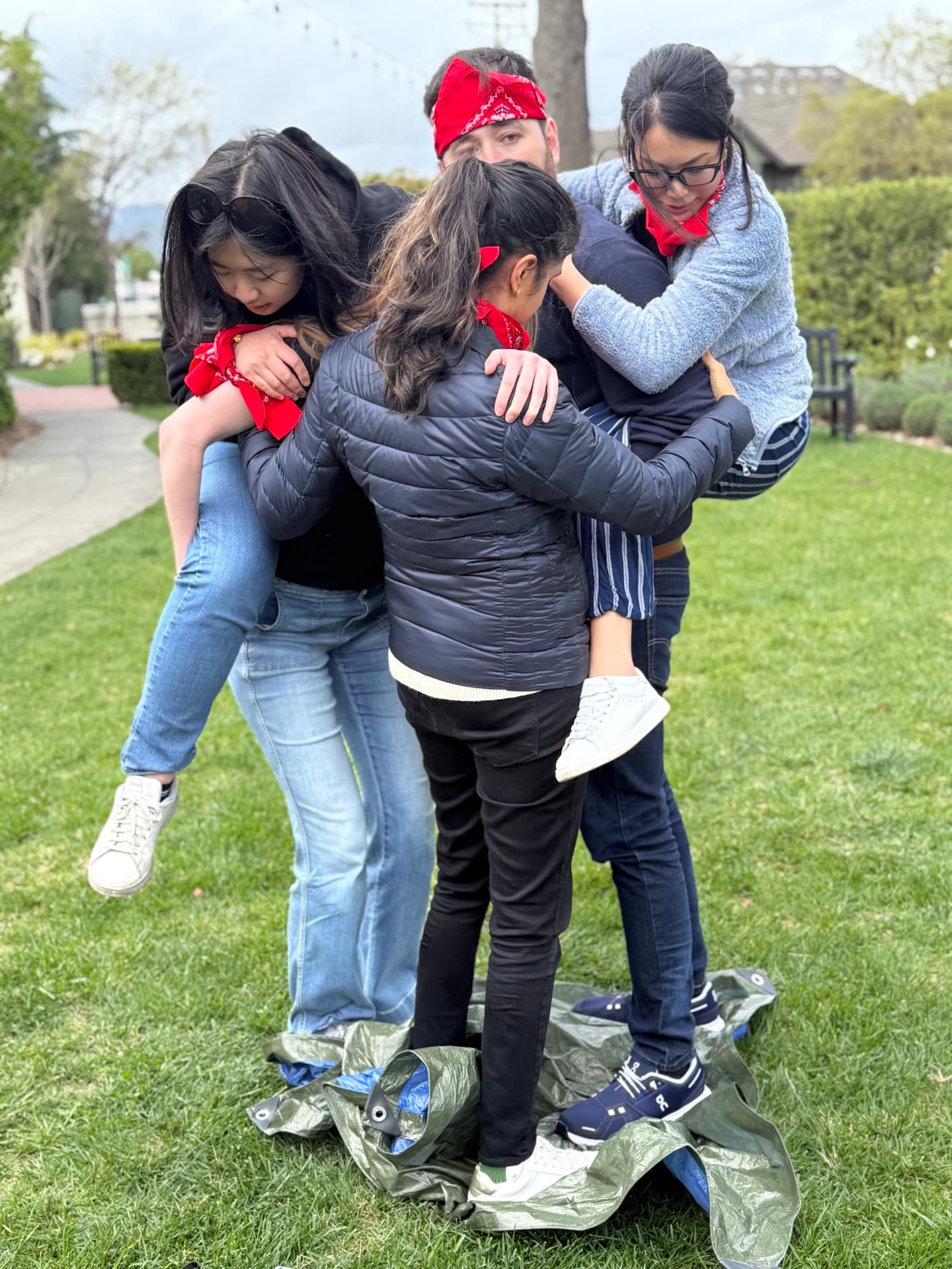 Team squeezing onto a shrinking tarp during a field challenge