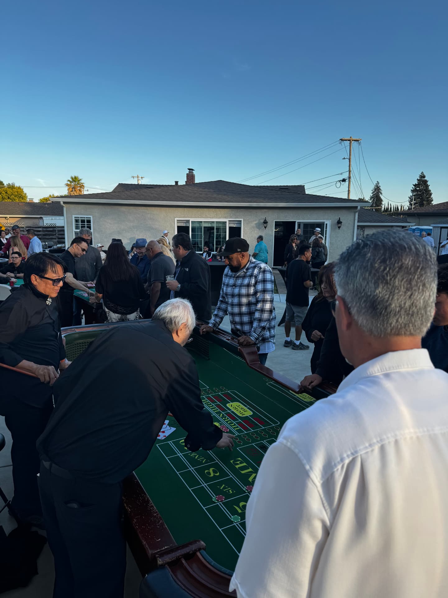 Guests around a casino craps table at an outdoor game night