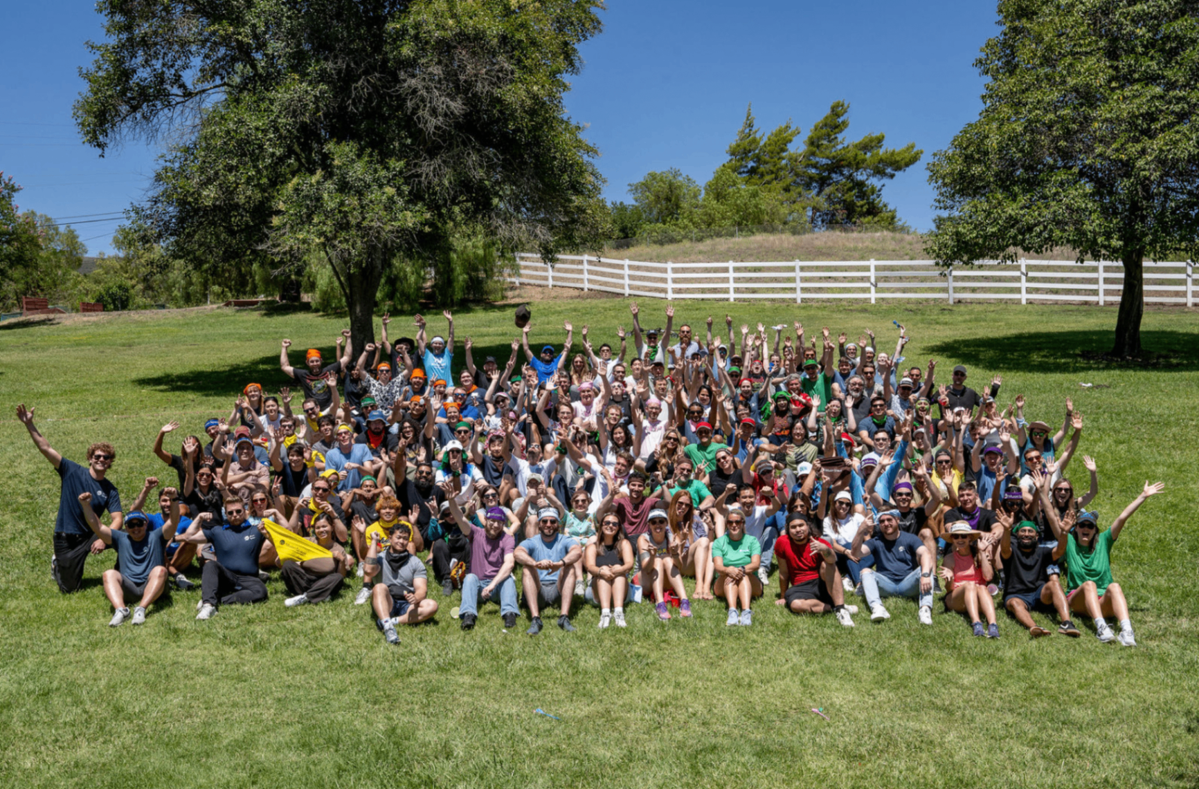 Full company group photo, arms in the air