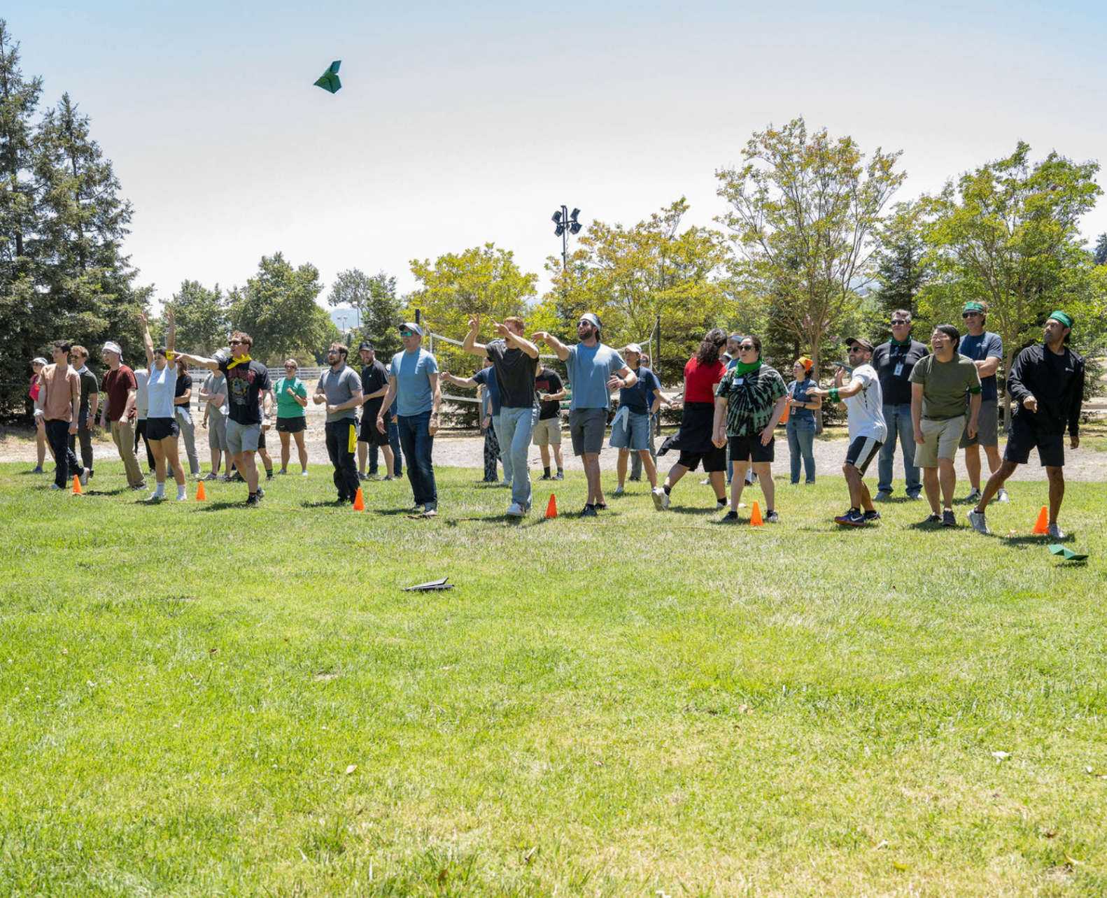 Crowd launching paper planes together on the lawn